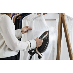 Likalnik Tefal pri navpičnem parnem likanju bele srajce na obešalniku.