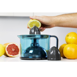 Cecotec sokovnik za citruse v modro-sivi barvi, prikazan med ožemanjem limone v zbirno posodo za sok.