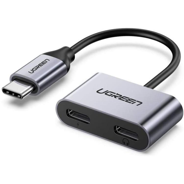 Kompakten USB-C adapter z dvema USB-C priključkoma za hkratno polnjenje in uporabo slušalk.