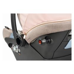 Detajl otroškega avtosedeža Peg Perego z gumbom za nastavitev in zadrgo