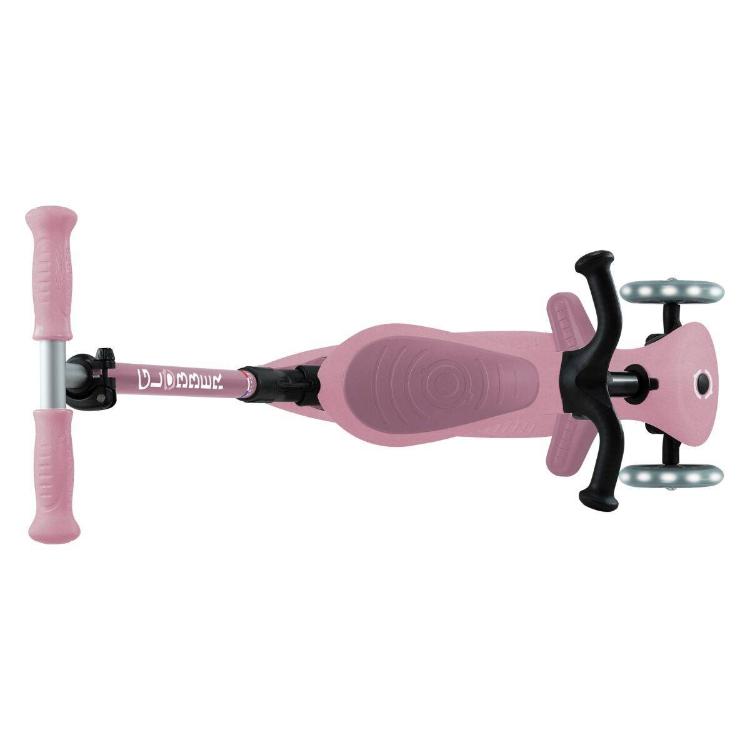 Pogled od zgoraj na roza otroški skiro s tremi kolesi