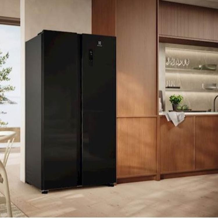 Črn ameriški hladilnik Electrolux s stekleno površino, postavljen v sodobni kuhinji.
