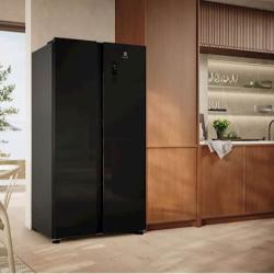 Črn ameriški hladilnik Electrolux s stekleno površino, postavljen v sodobni kuhinji.