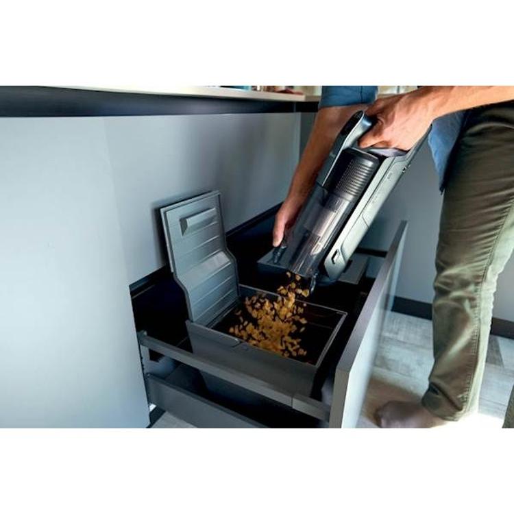 Praznjenje posode za prah baterijskega sesalnika Hoover HF350HP neposredno v koš.