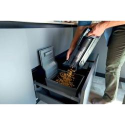 Praznjenje posode za prah baterijskega sesalnika Hoover HF350HP neposredno v koš.