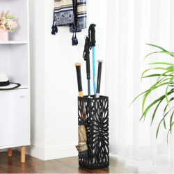 Kovinsko stojalo za dežnike v predsobi, napolnjeno z dežniki in pohodnimi palicami.