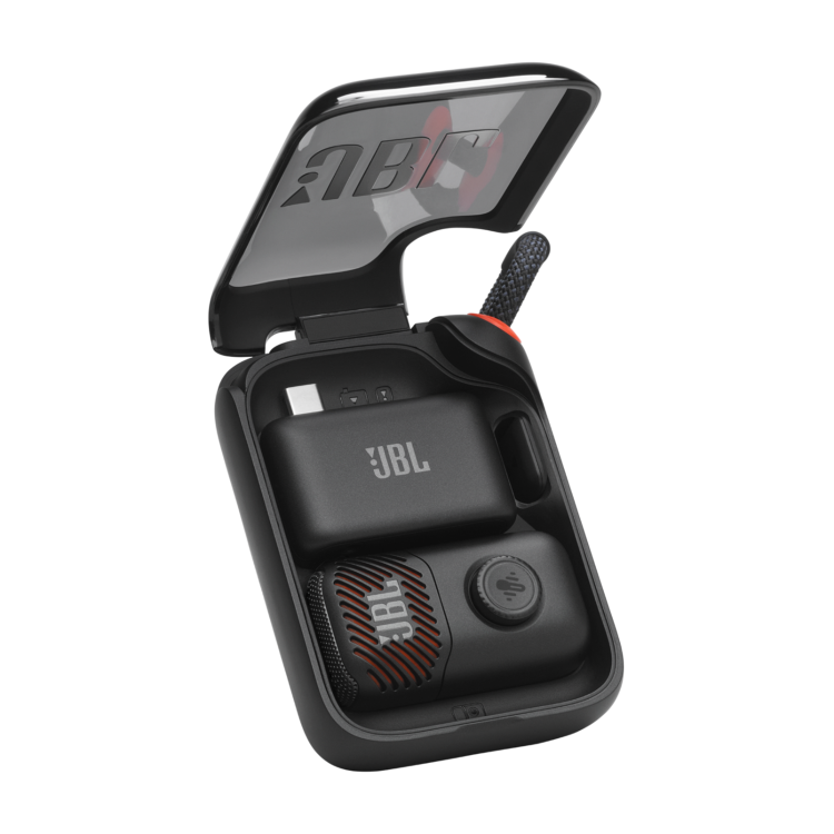 Odprto polnilno ohišje JBL EasySing Mic Mini z mikrofonom, USB‑C sprejemnikom in paščkom za prenašanje.