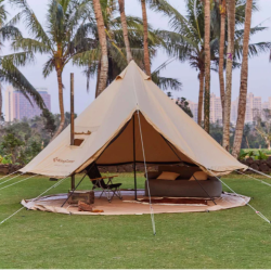 Glamping šotor KingCamp postavljen na travi med palmami, prostorna notranjost z odprtim vhodom in vrvmi za stabilnost.